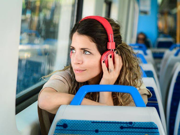 Frau mit Kopfhörern in der Bahn